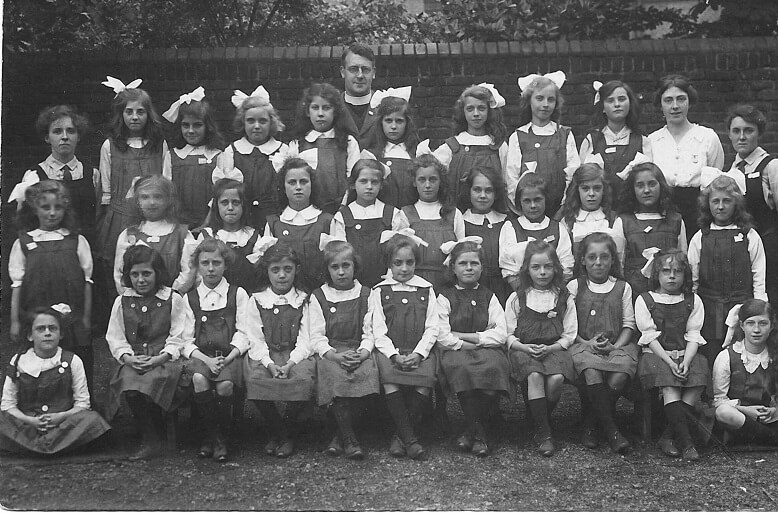 Black and white photo on a postcard of schoolgirls