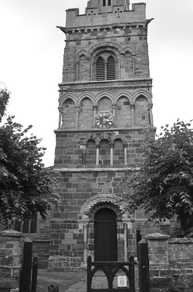 Black and white photo showing the tower of the church of St Andrew, Spratton, Northamptonshire